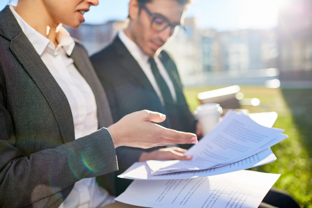 Professionals reviewing and pointing at a contract, symbolizing detailed payroll compliance.